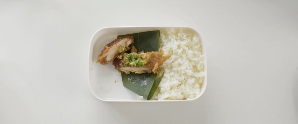 お弁当の中で重ねたおかずが滑り落ちる